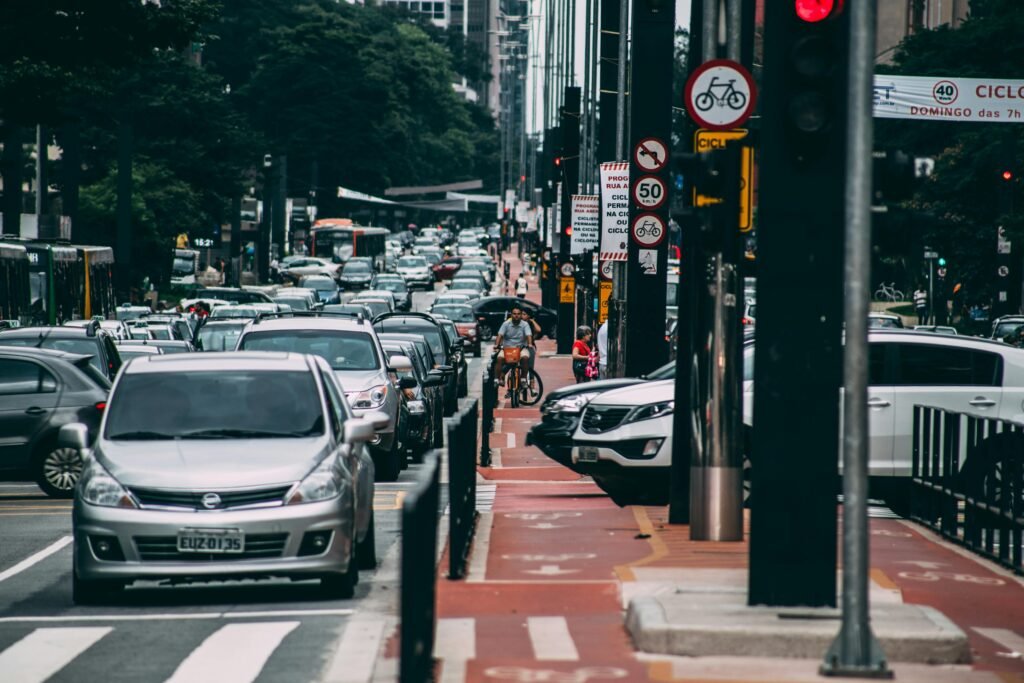 Urban street scene with heavy traffic and cyclists in a bustling city environment.